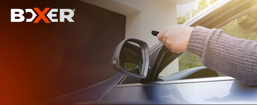 Boxer Garagentoröffner – Person öffnet automatisches Garagentor mit Fernbedienung vom Auto