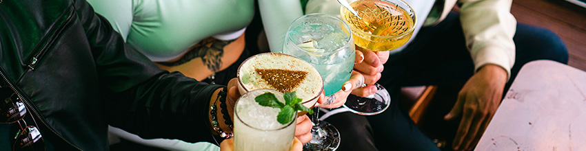 Vier schicke Drinks werden angestoßen.